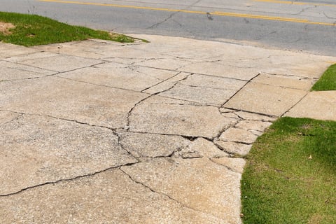 Cracked and broken concrete driveway showing structural damage