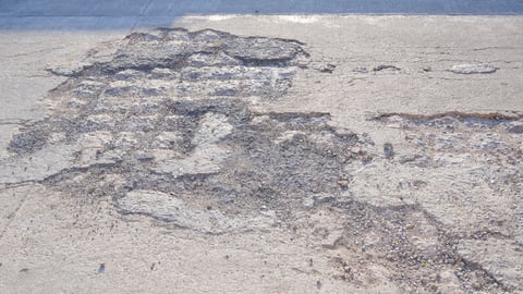 Cracks and broken texture of damaged concrete street surface