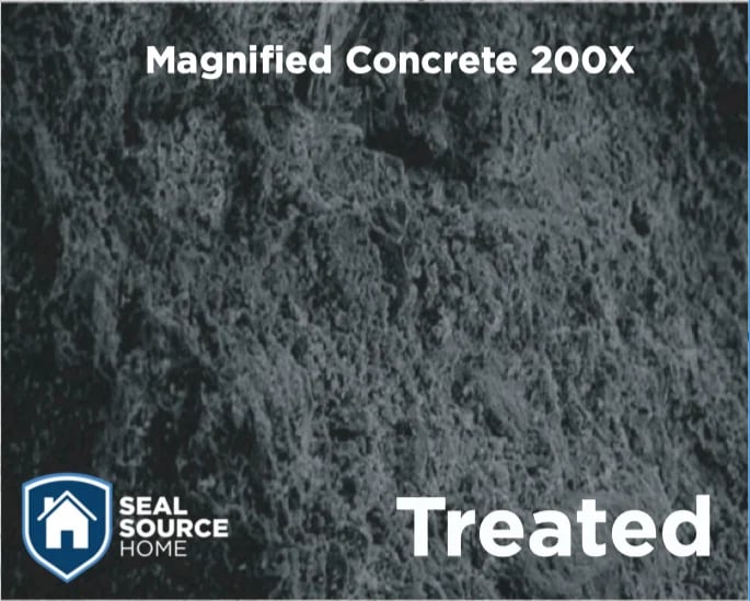 Magnified concrete surface at 200X magnification showing treated finish with dark textured appearance